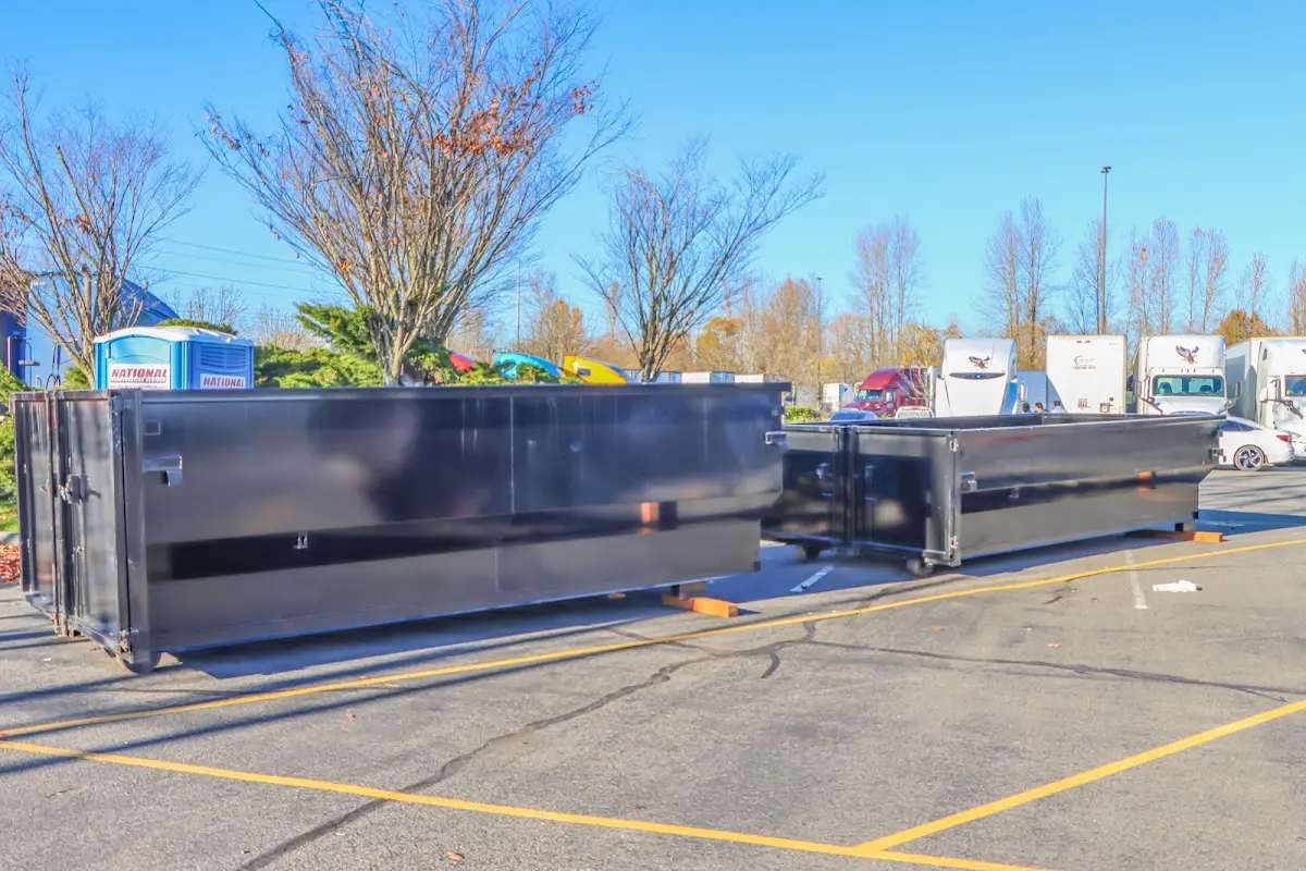 Professional dumpster rental service with roll-off container on residential driveway in Valley